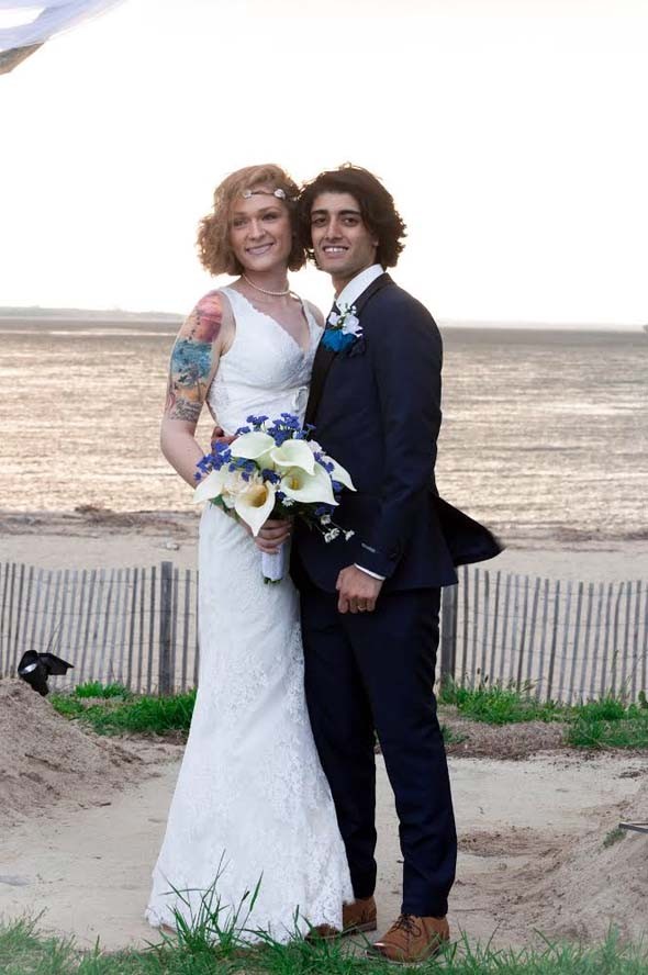 Bride and groom posing for picture on beach