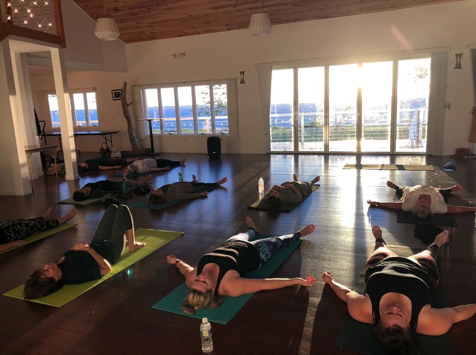 Yoga session - women laying on backs on yoga mats