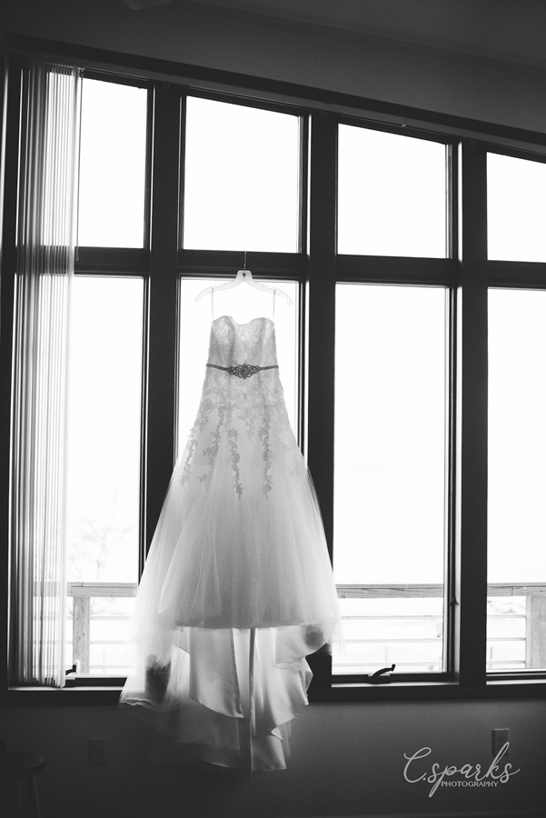 Black and white photo of bride's gown hung up