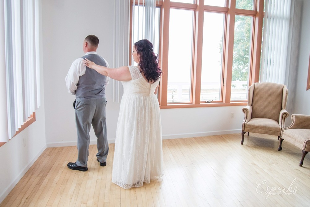 Bride with arm extended out and hand on groom's back