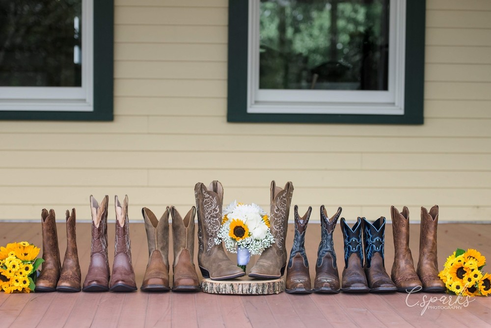 Cowboy and cowgirl boots all lined up with flowers at center