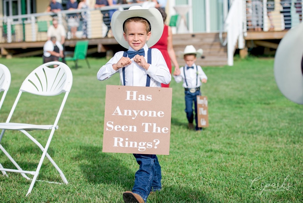 Ringbearer wearing sign that says Has Anyone Seen the Rings?