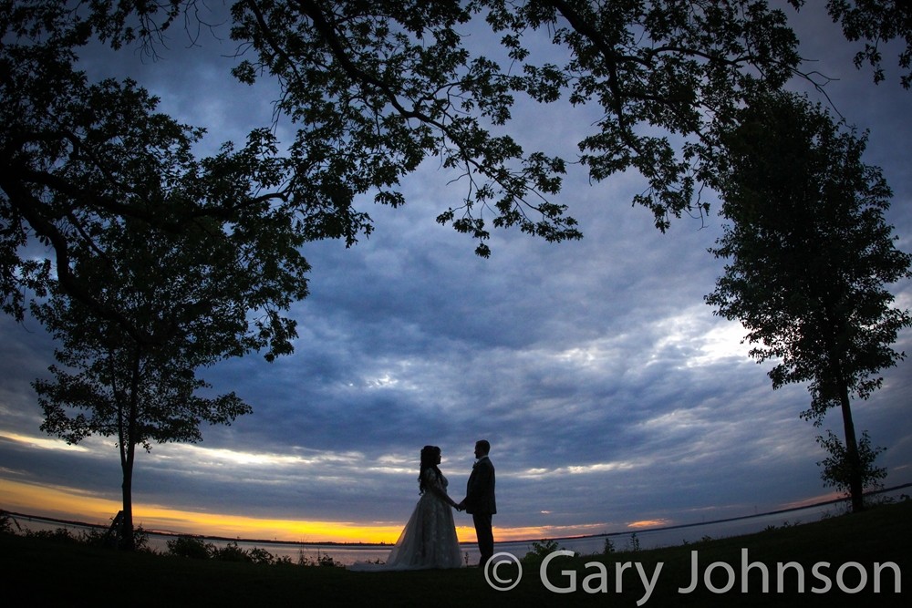Bride and groom silhouettes with sunset and t