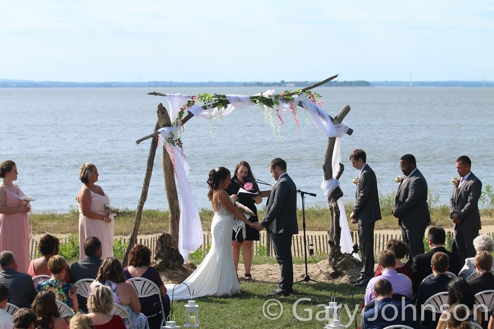 Wedding on beach with bride and groom under manor