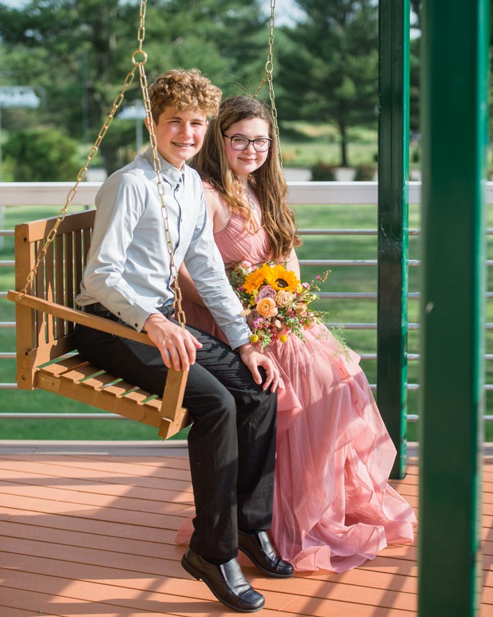 Prom boy and girl sitting on porch swing