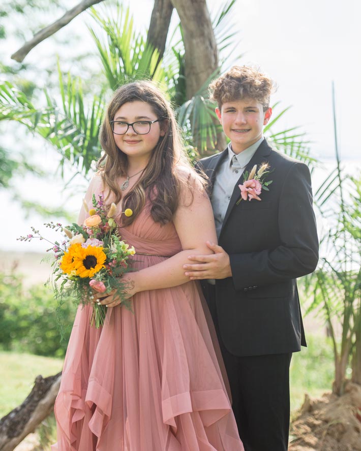 Young prom couple posing outside