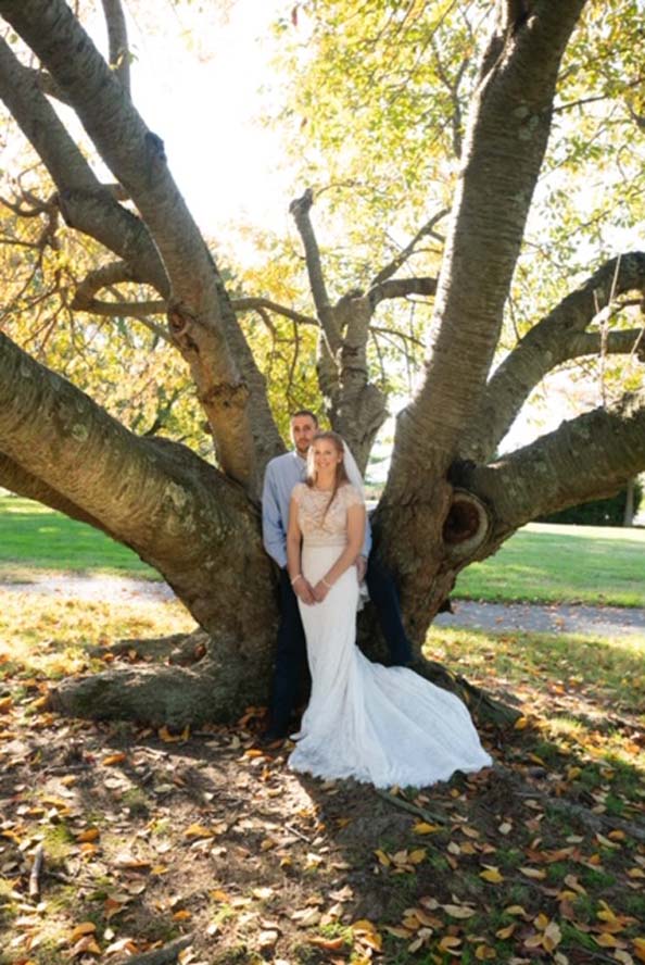Bride and groom infront of large tree