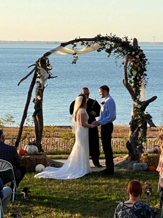 Bride and groom getting married under arch